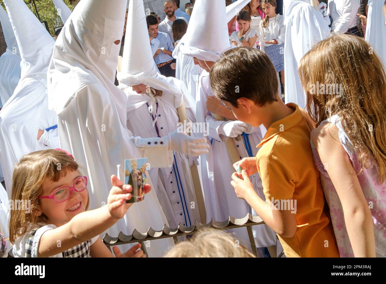 Siviglia Spagna. Settimana Santa o Semana Santa. I bambini vengono dati dei dolci durante la processione alla Cattedrale di Siviglia la Domenica delle Palme, Domingo de Ramos. Foto Stock