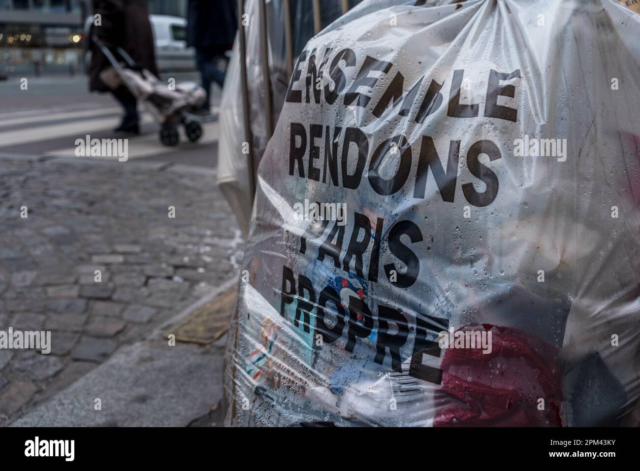Sacco per spazzatura per strada con 'facciamo Parigi pulita insieme' scritto in francese. Parigi, Francia. Foto Stock