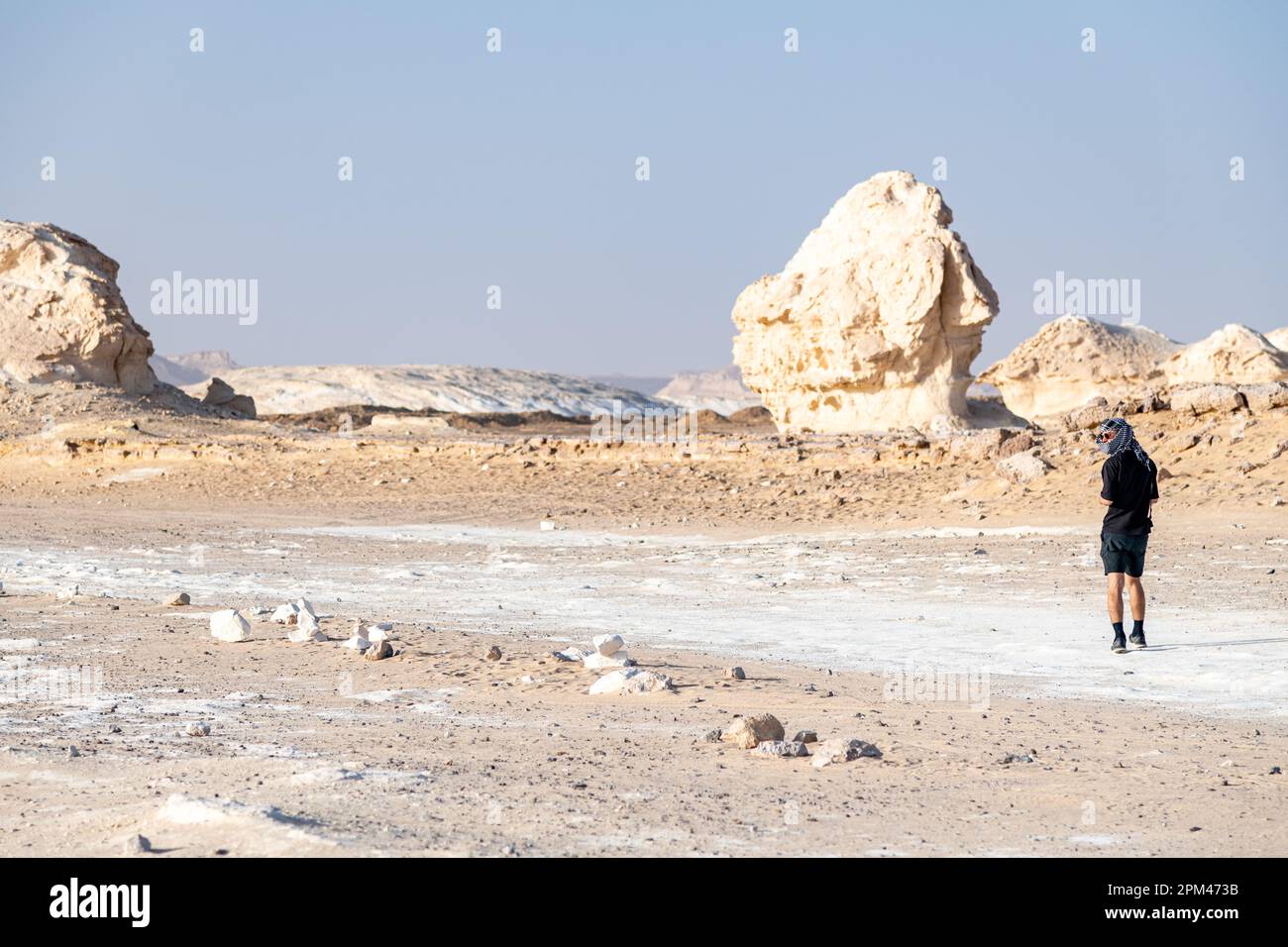 Un turista che esplora il paesaggio bianco del deserto di roccia del gesso a Bahariya in Egitto Foto Stock