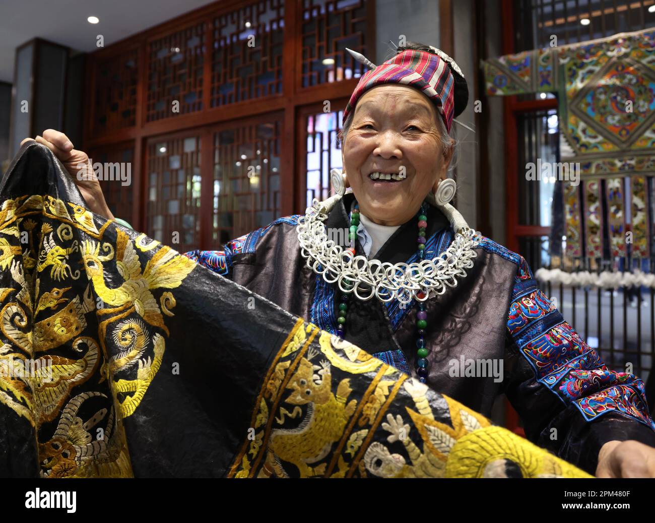Guiyang, provincia cinese di Guizhou. 6th Apr, 2023. Pan Yuzhen, un ricamatore di 77 anni, mostra il suo costume Miao fatto a mano a Guiyang, capitale della provincia di Guizhou nella Cina sudoccidentale, il 6 aprile 2023. PER ANDARE CON 'attraverso la Cina: Il ricamo tradizionale promuove 'China chic' nella moda globale' Credit: Sui Xiaoqiang/Xinhua/Alamy Live News Foto Stock