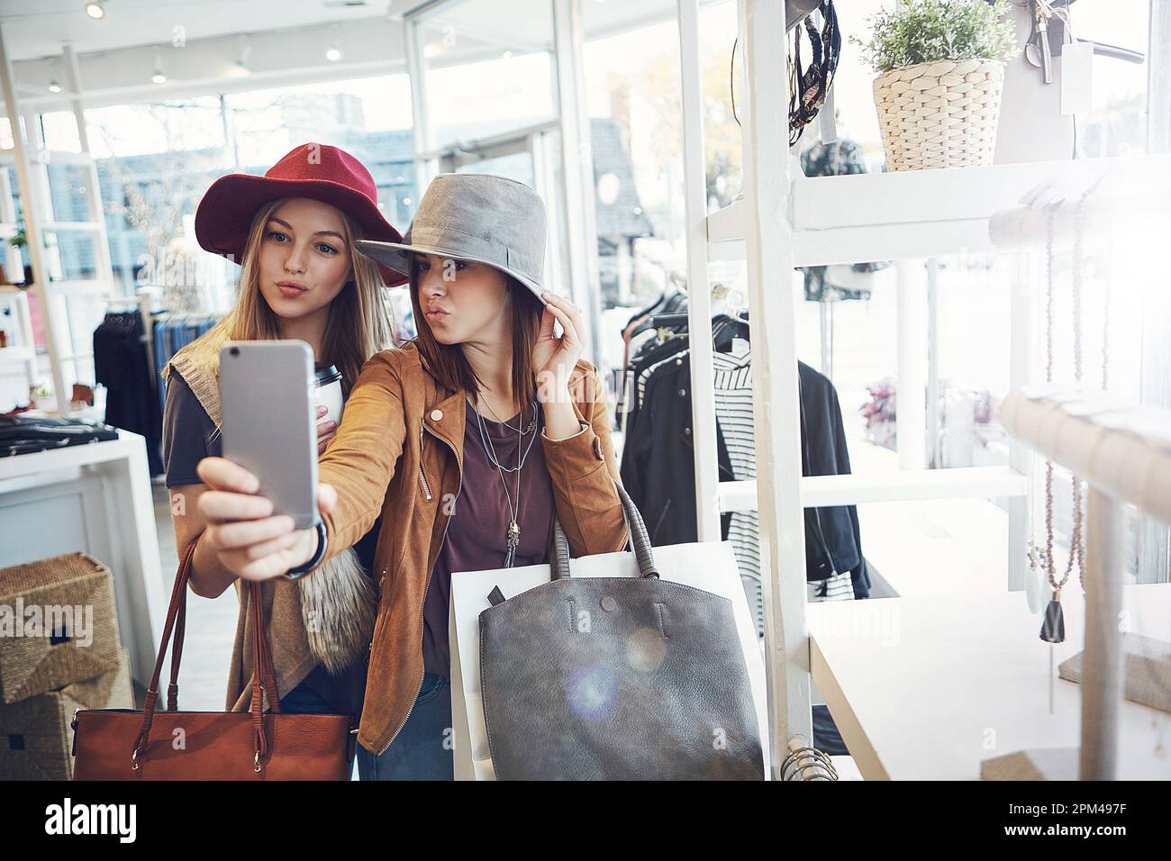 Fai shopping fino al prossimo selfie. due giovani fidanzate scattano selfie mentre si è in giro per lo shopping. Foto Stock