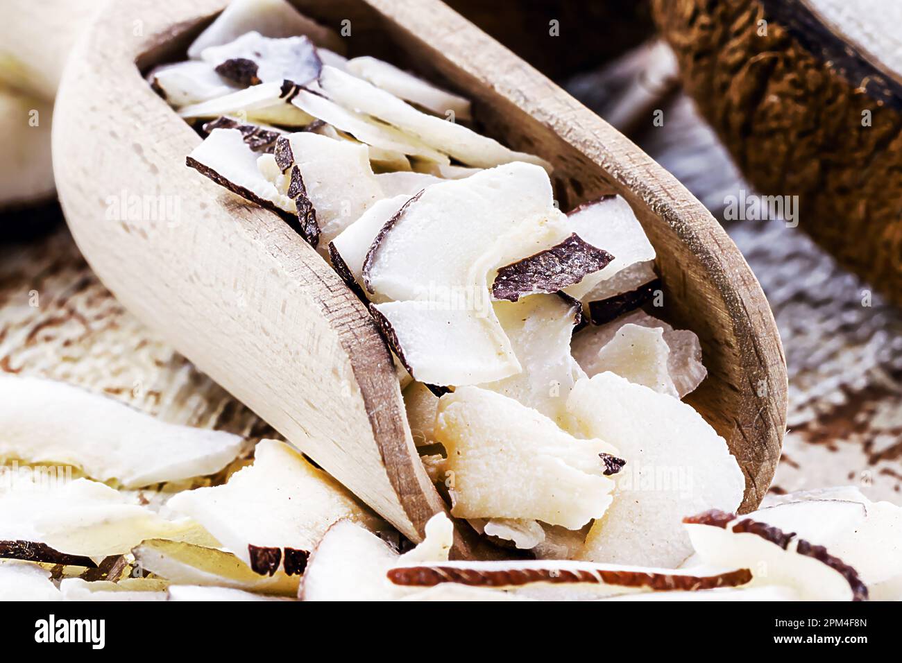 Misurino in legno con pezzi e trucioli di cocco, ingrediente per cucinare, MACROFOTOGRAFIA Foto Stock