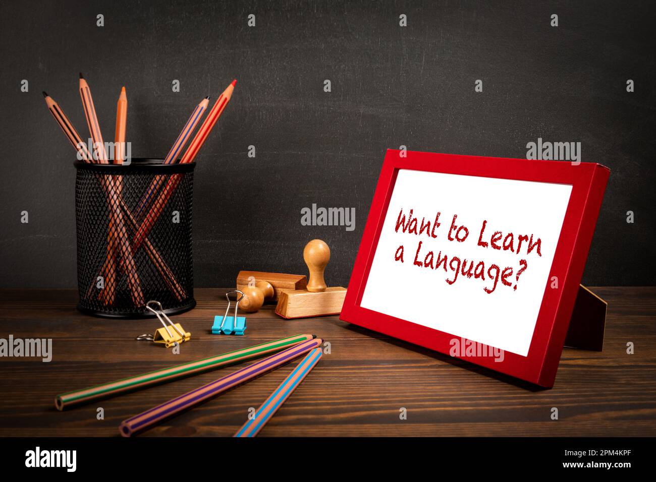 Vuoi imparare una lingua. Cornice con testo su tavolo in legno. Foto Stock
