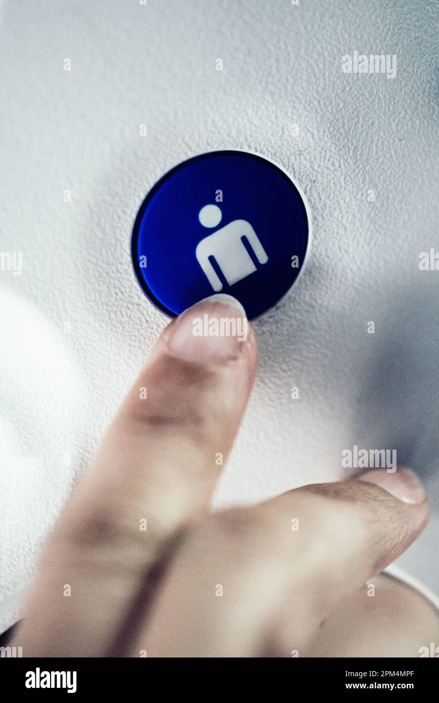 Il passeggero preme un pulsante sul pannello sopra la testa per accendere la ventola dell'aria condizionata e l'illuminazione all'interno dell'aeromobile Foto Stock