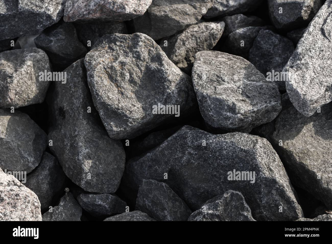 Pietre grigio scuro che coprono il terreno in cantiere. Texture foto di sfondo Foto Stock