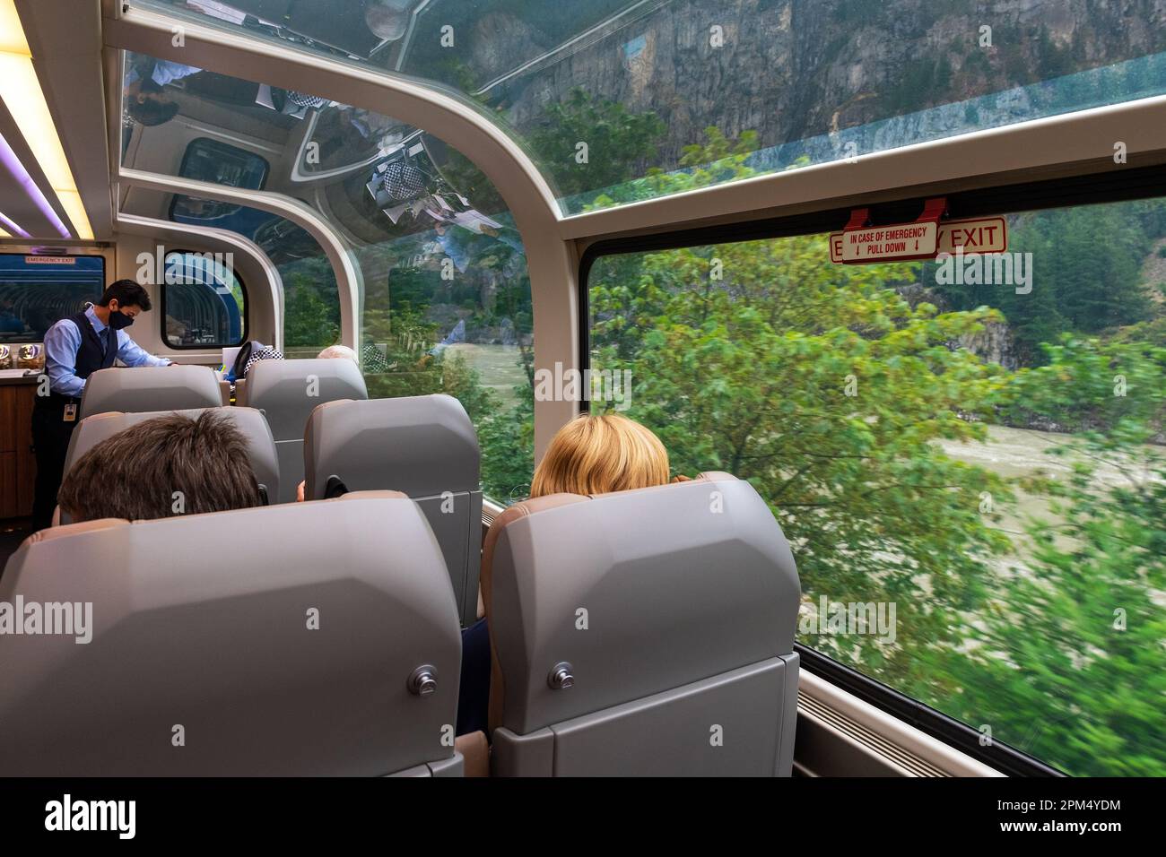Passeggeri nel carro ferroviario panoramico a 360 gradi Rocky Mountaineer in foglia d'oro lungo il fiume Fraser, British Columbia, Canada. Foto Stock