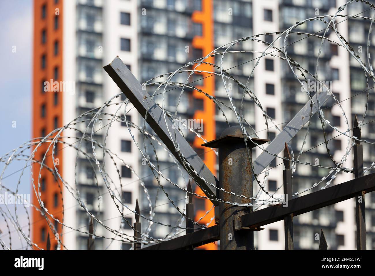 Filo spinato sul fondo dell'edificio residenziale. Concetto di guerra e sicurezza in città Foto Stock