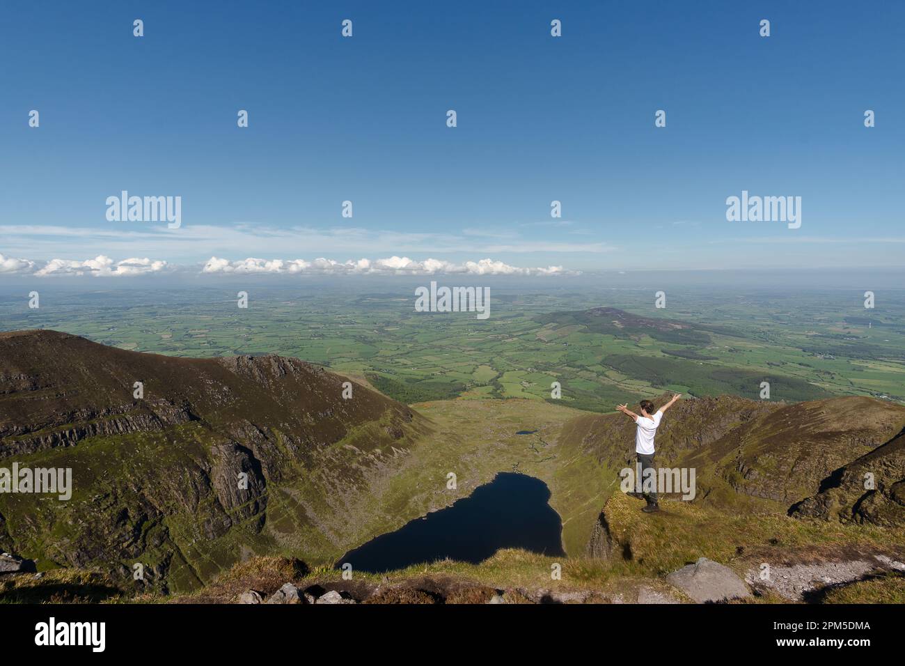 Uomo scalatore in cima al lago Coumshingaun Irlanda Foto Stock