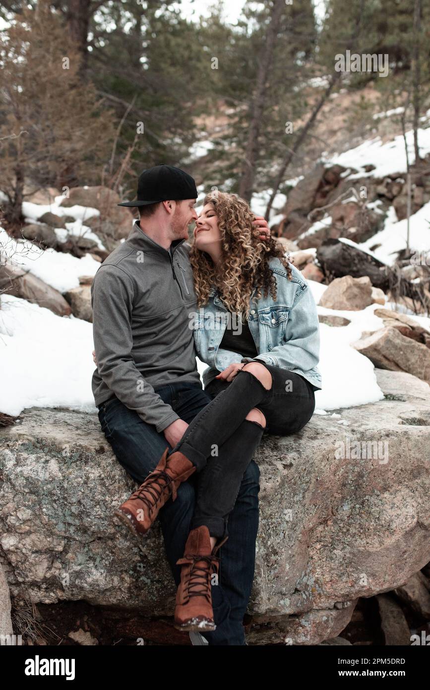 Coppia avventurosa seduta insieme sulle montagne del Colorado in inverno Foto Stock
