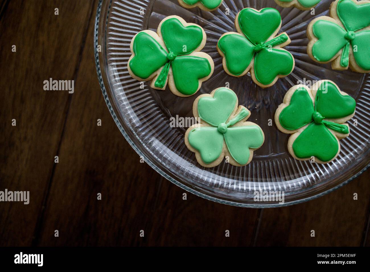 Vista dall'alto dei biscotti Shamrock ghiacciati verdi sulla lastra di vetro Foto Stock