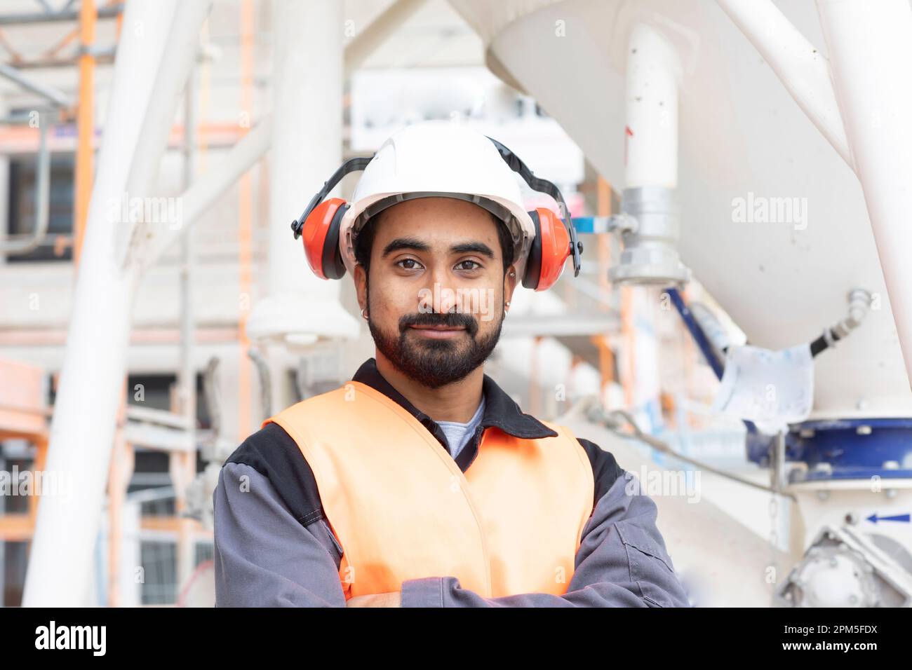 giubbotto di sicurezza giovane tecnico e casco funzionante Foto Stock