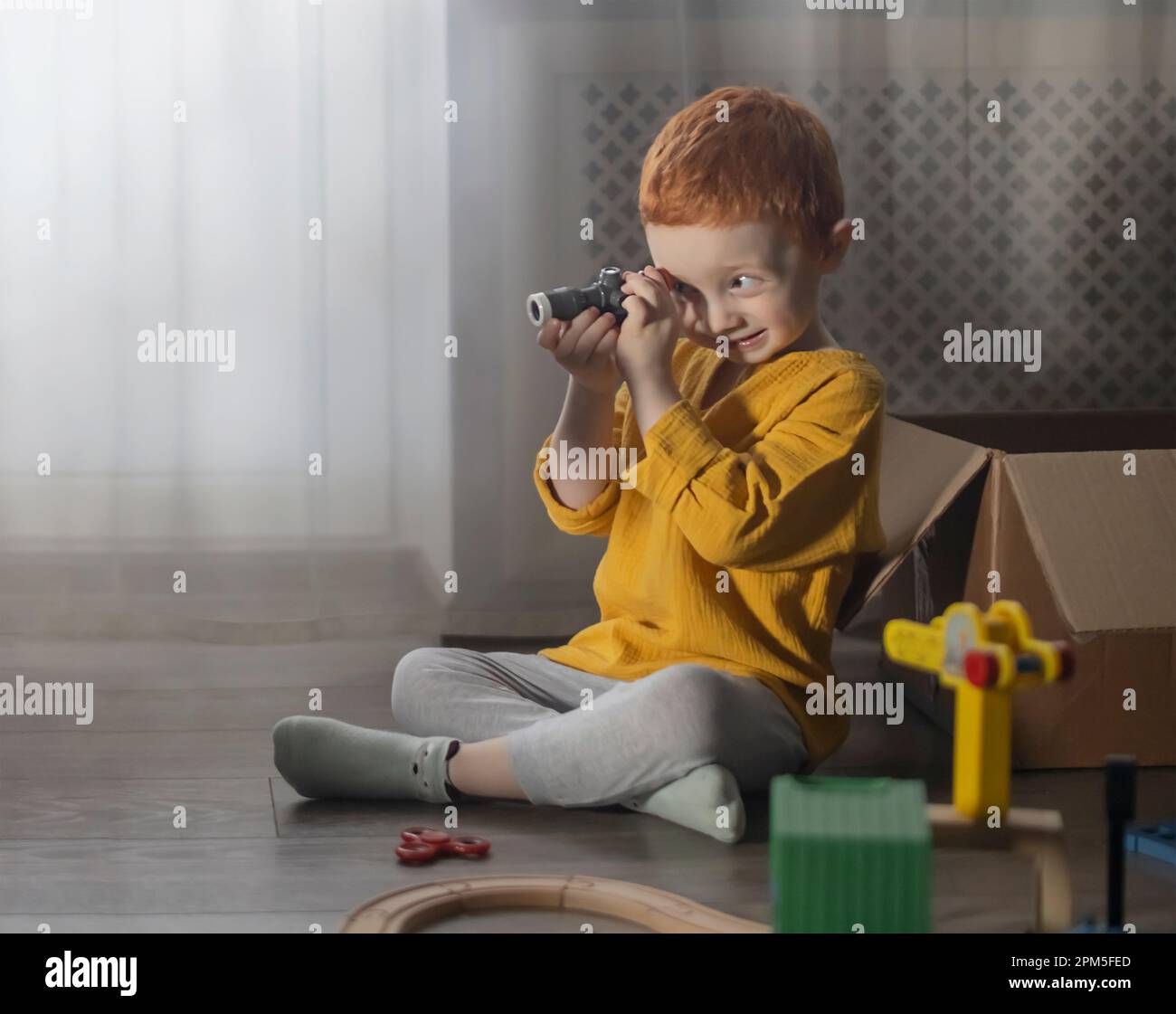 Il bambino guarda attraverso una lente di ingrandimento giocattolo. Foto Stock