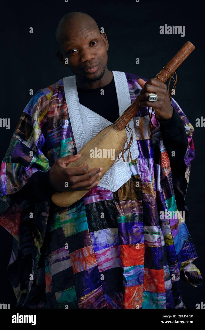 Musicista africano con strumenti a corda e abiti tipici. Foto Stock