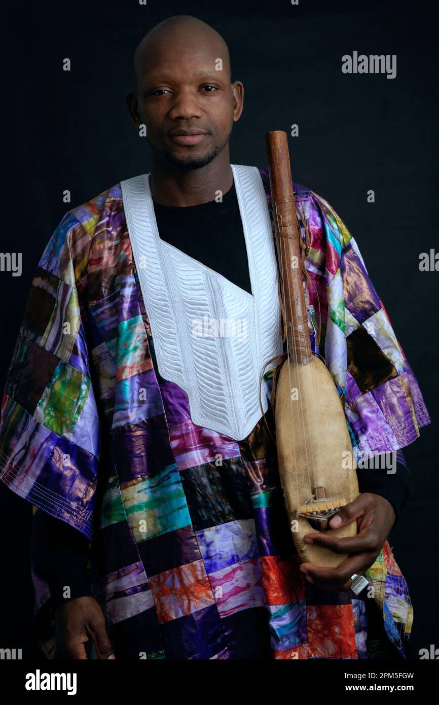 Musicista africano con strumenti a corda e abiti tipici. Foto Stock