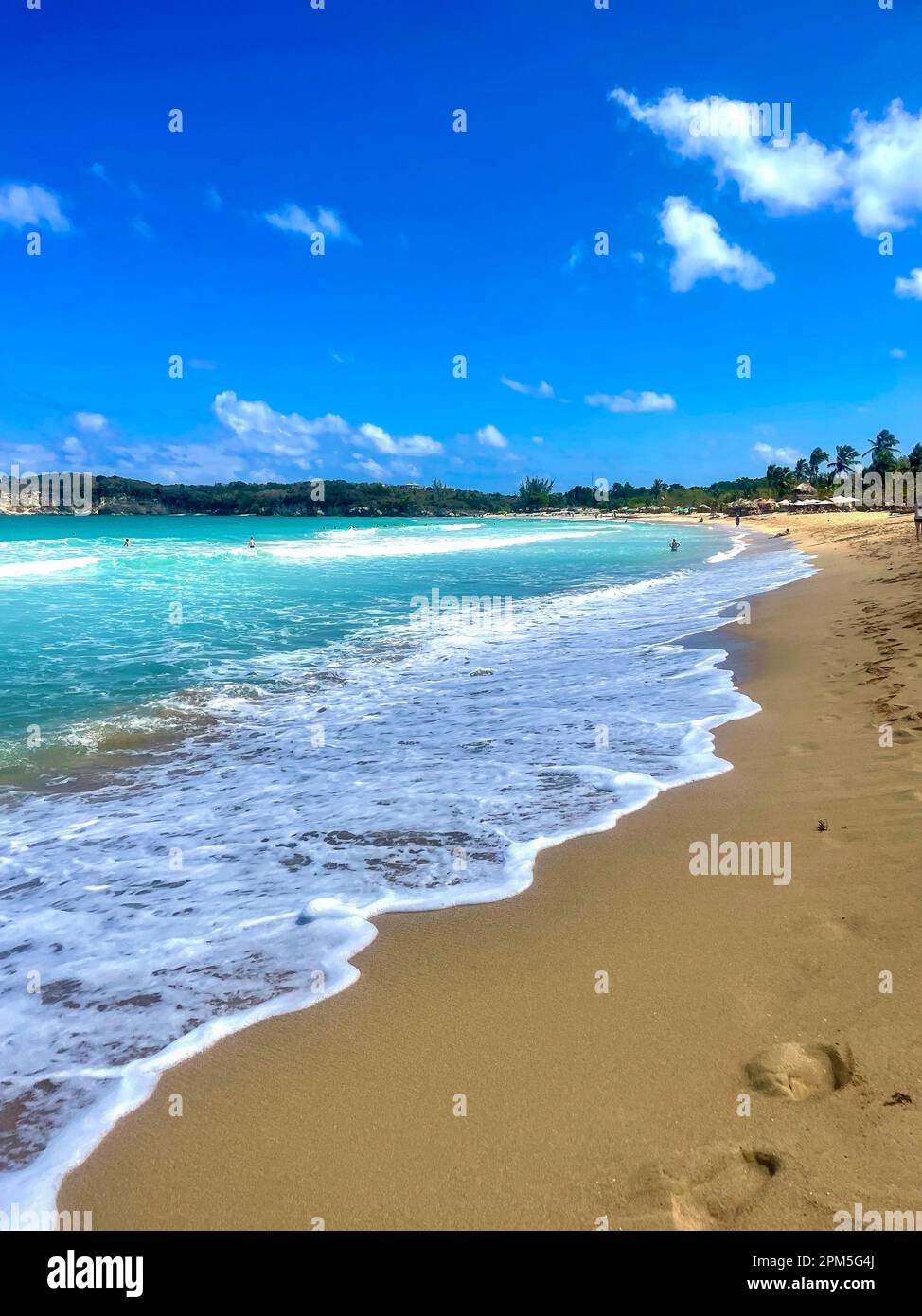 Idilliaca spiaggia di sabbia bianca dei Caraibi con acqua blu e schiuma di mare bianca Foto Stock