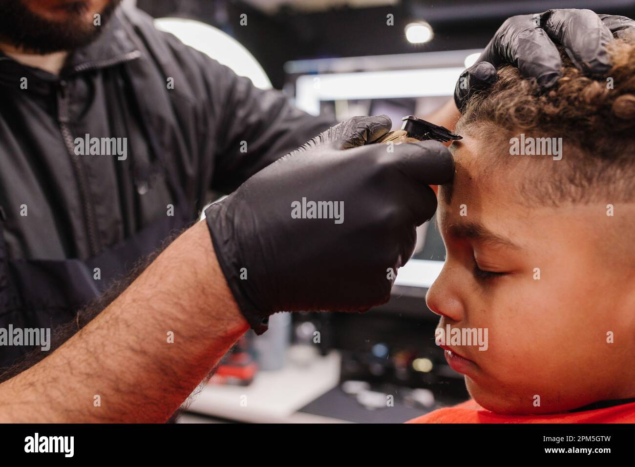 Ragazzo biraciale con i capelli tagliati e i bordi allineati dal barbiere Foto Stock