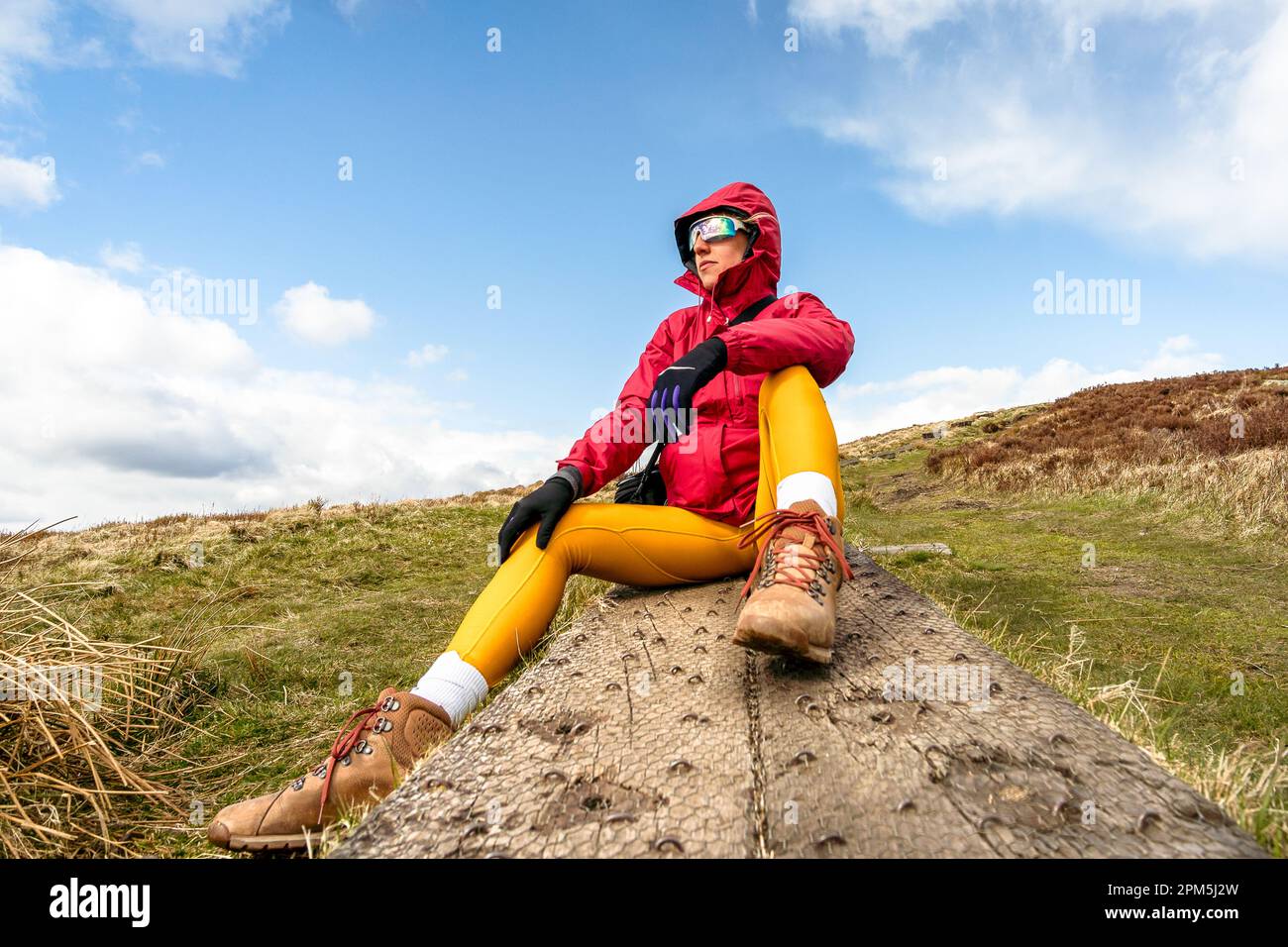 donna alpinista seduta su passerella di legno Foto Stock