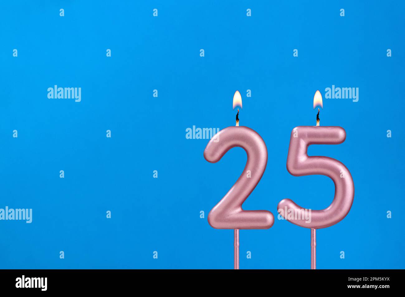 Numero 25 - candela anniversario di bruciatura su sfondo blu schiumoso Foto Stock