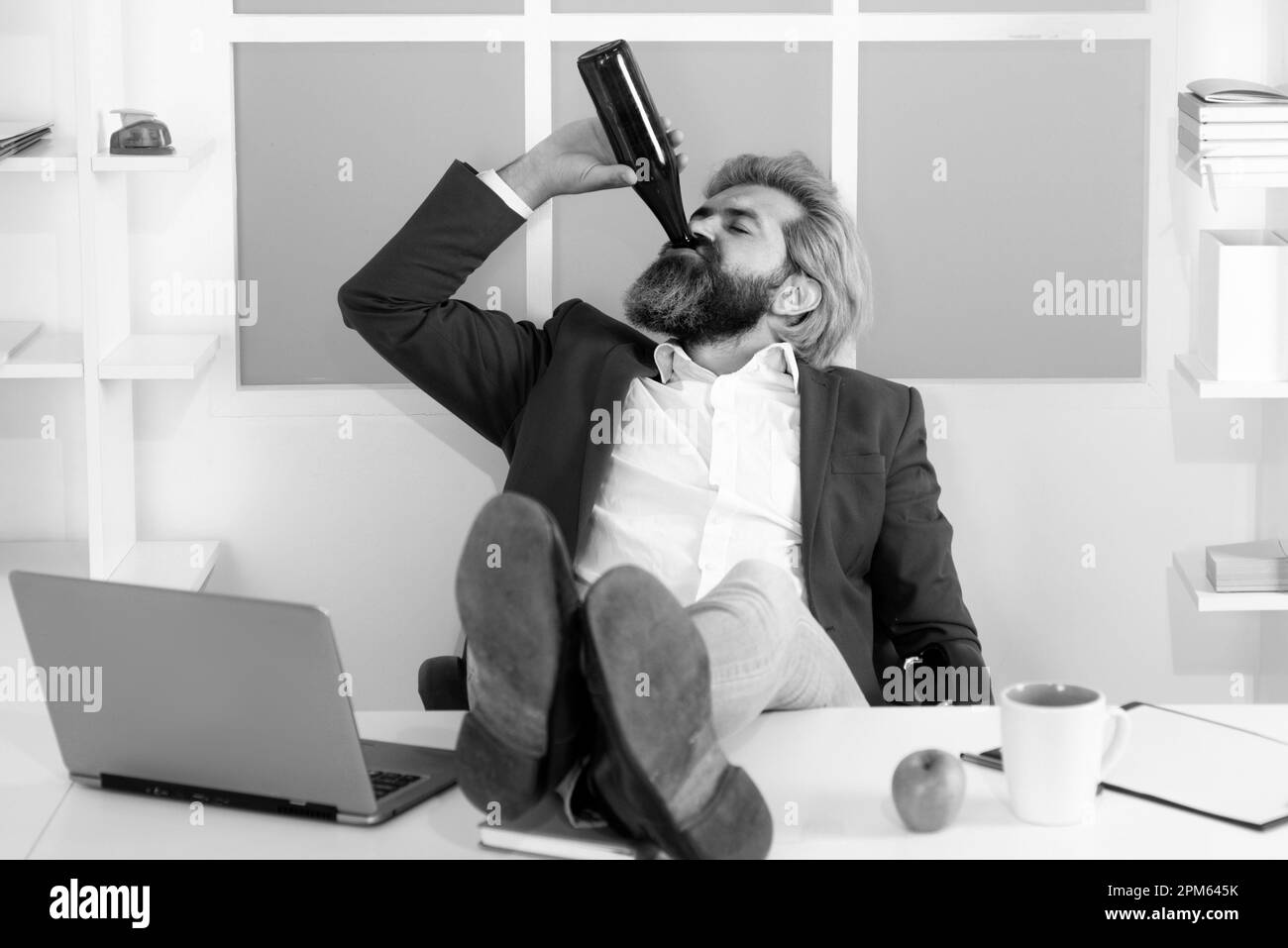 Impiegato che beve birra in ufficio. Divertente lavoro di ufficio che va pazzo di alcol. Ubriaco dipendente business manager alzarsi seduta in sedia. Foto Stock