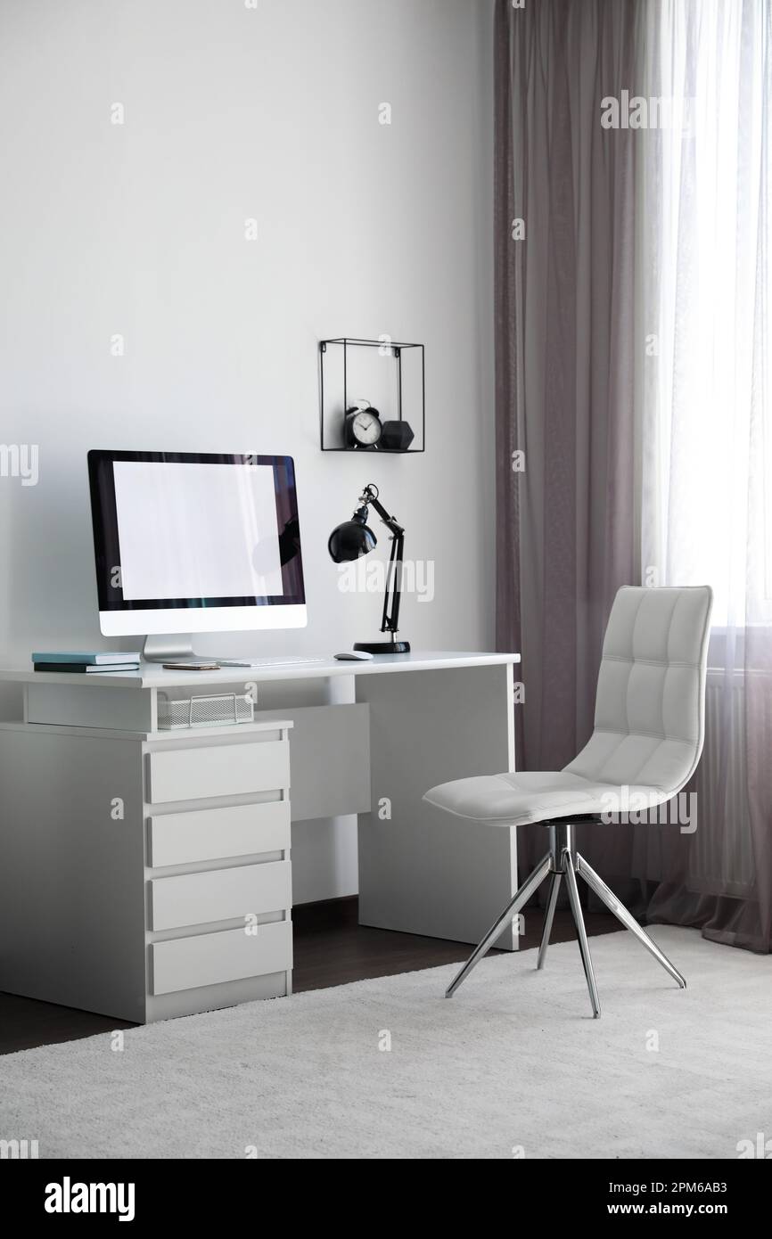 Comoda sedia bianca vicino alla scrivania in un elegante ufficio