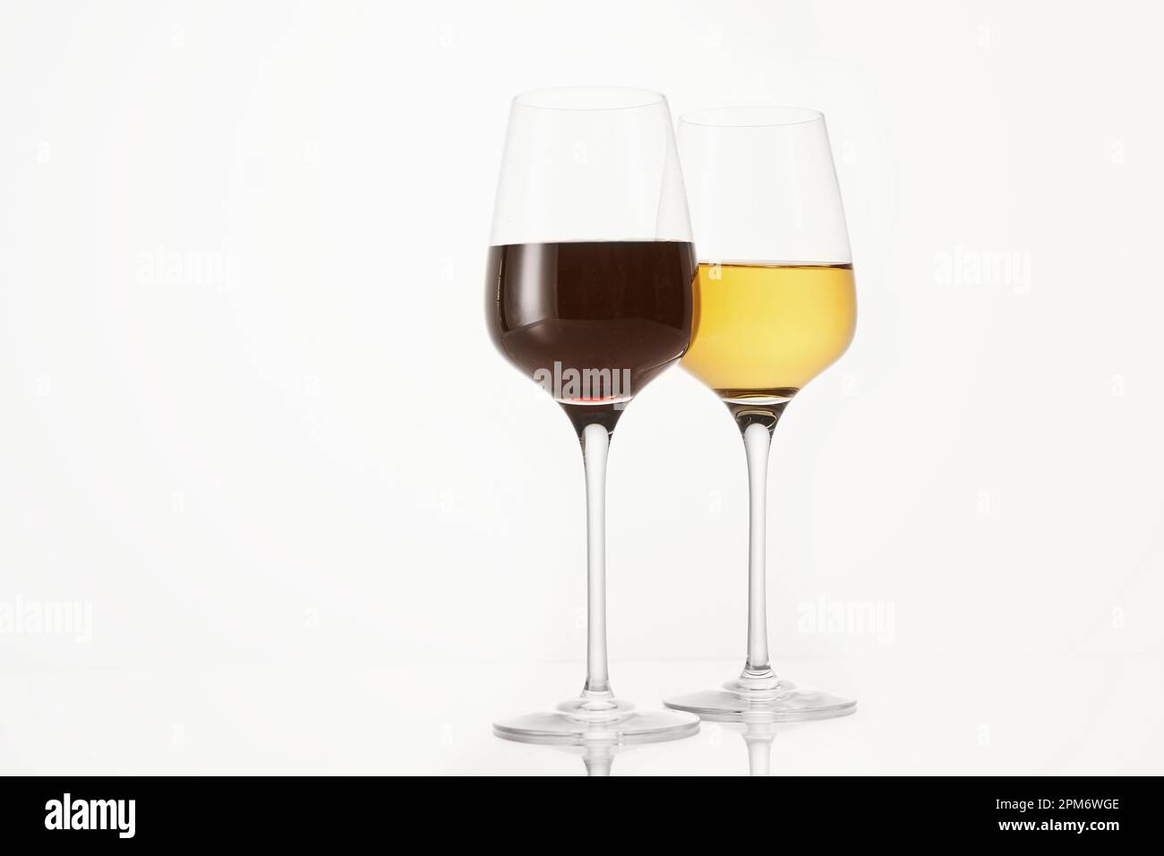 Due viticolli riempiti a metà con vino rosso e bianco. Foto Stock