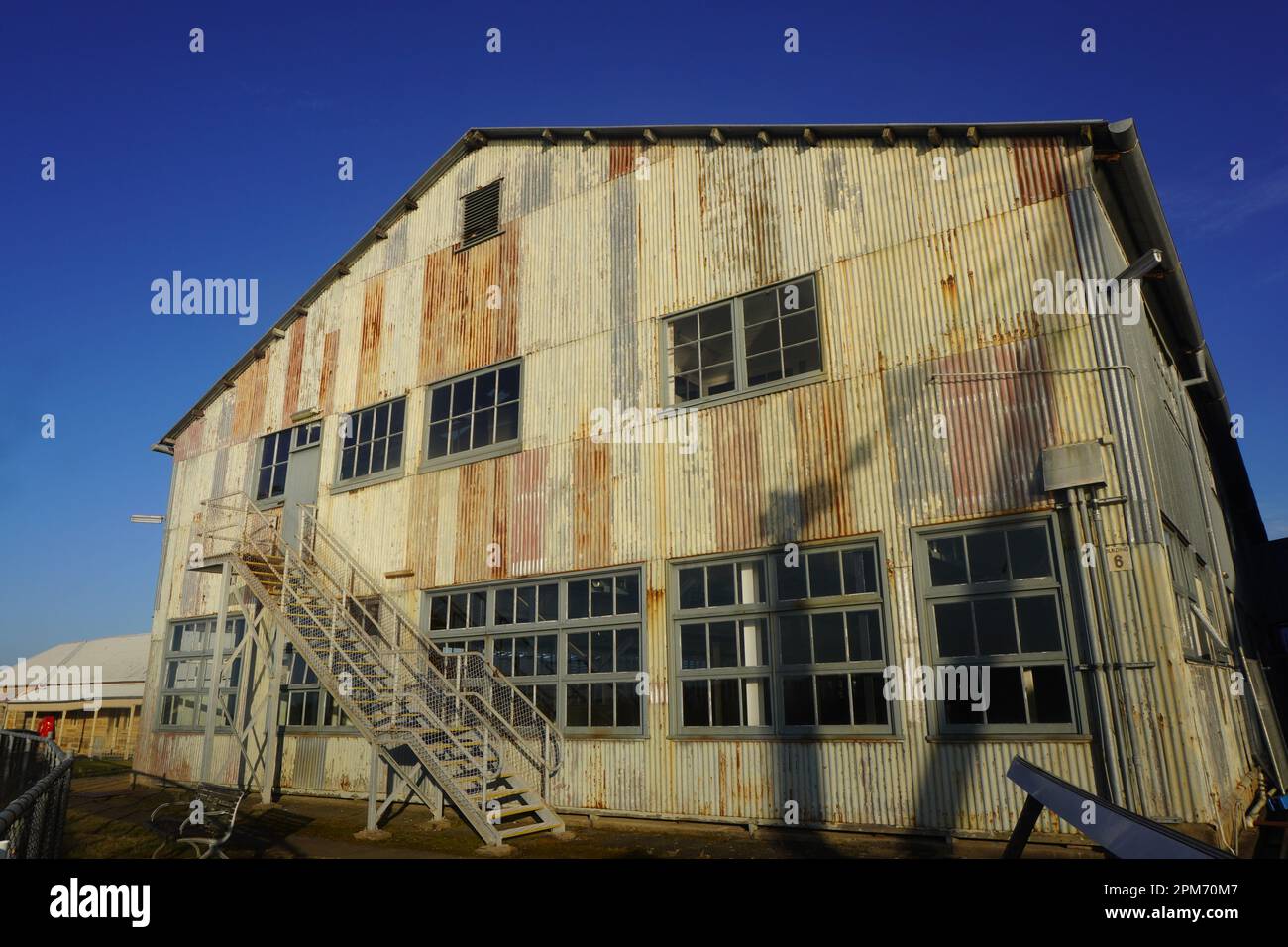 Vecchio edificio arrugginito nel quartiere di Ship Design di Cockatoo Island a luce mattutina brillante Foto Stock