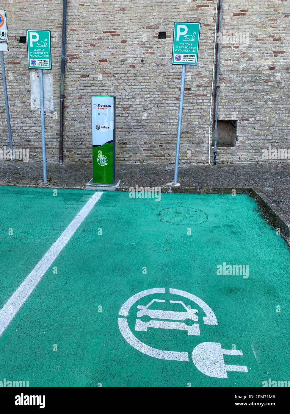 Loreto, Ancona, Italia - Aprile 2023 Stazione di ricarica per veicoli elettrici in prossimità delle mura della Basilica cartello e posto auto per 2 auto Foto Stock