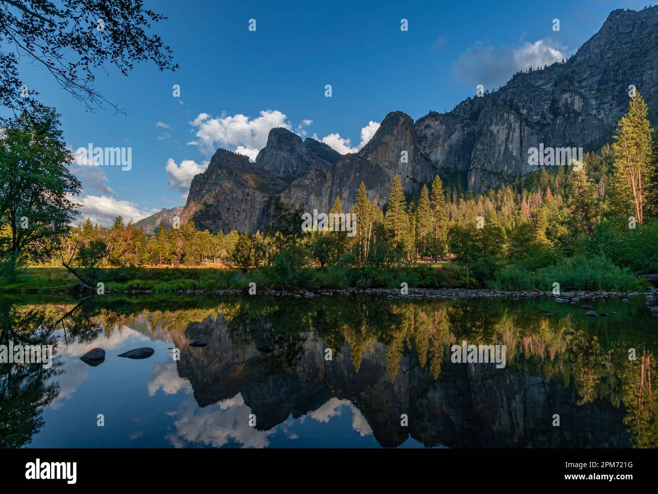 Il cielo blu domina le montagne e il fiume Merced nella Valle di Yosemite, il Parco Nazionale di Yosemite, Calfornia Foto Stock