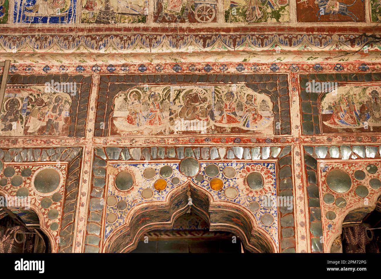Dipinti mitologici colorati e lavori a specchio sul soffitto di un piccolo Shani Mandir, situato a Ramgarh, Shekhawati, Rajasthan, India Foto Stock