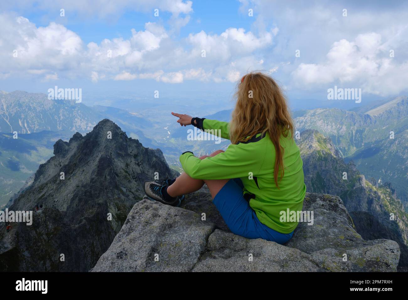Donna escursionista punta il dito verso una cima degli alti Tatra, Slovacchia. Escursioni, trekking, avventura, attivo, attività, natura. Foto Stock