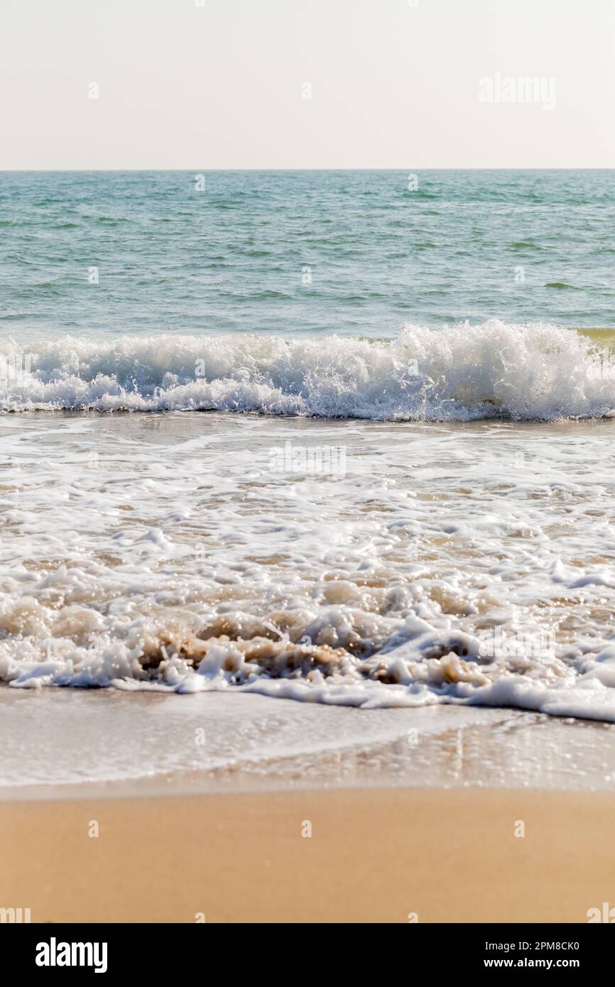 Immagine verticale di onde che si infrangono su una spiaggia sabbiosa. Swanage, Dorset, Inghilterra, Regno Unito Foto Stock