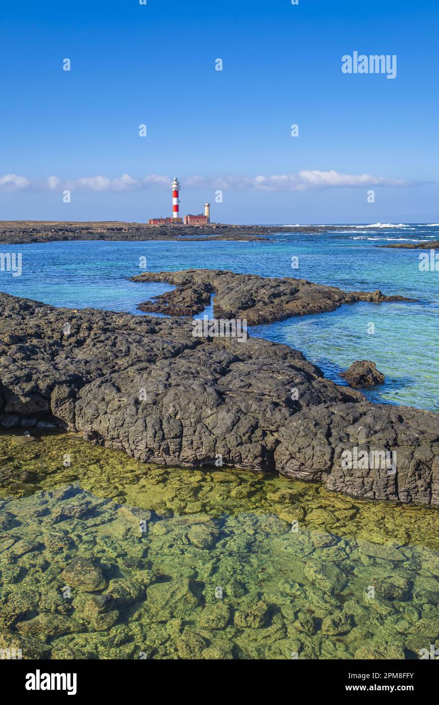 Spagna, Isole Canarie, Fuerteventura, El Cotillo, insenatura e piscine naturali della Caleta del Marrajo, faro di Toston a Punta de la Ballena sullo sfondo Foto Stock