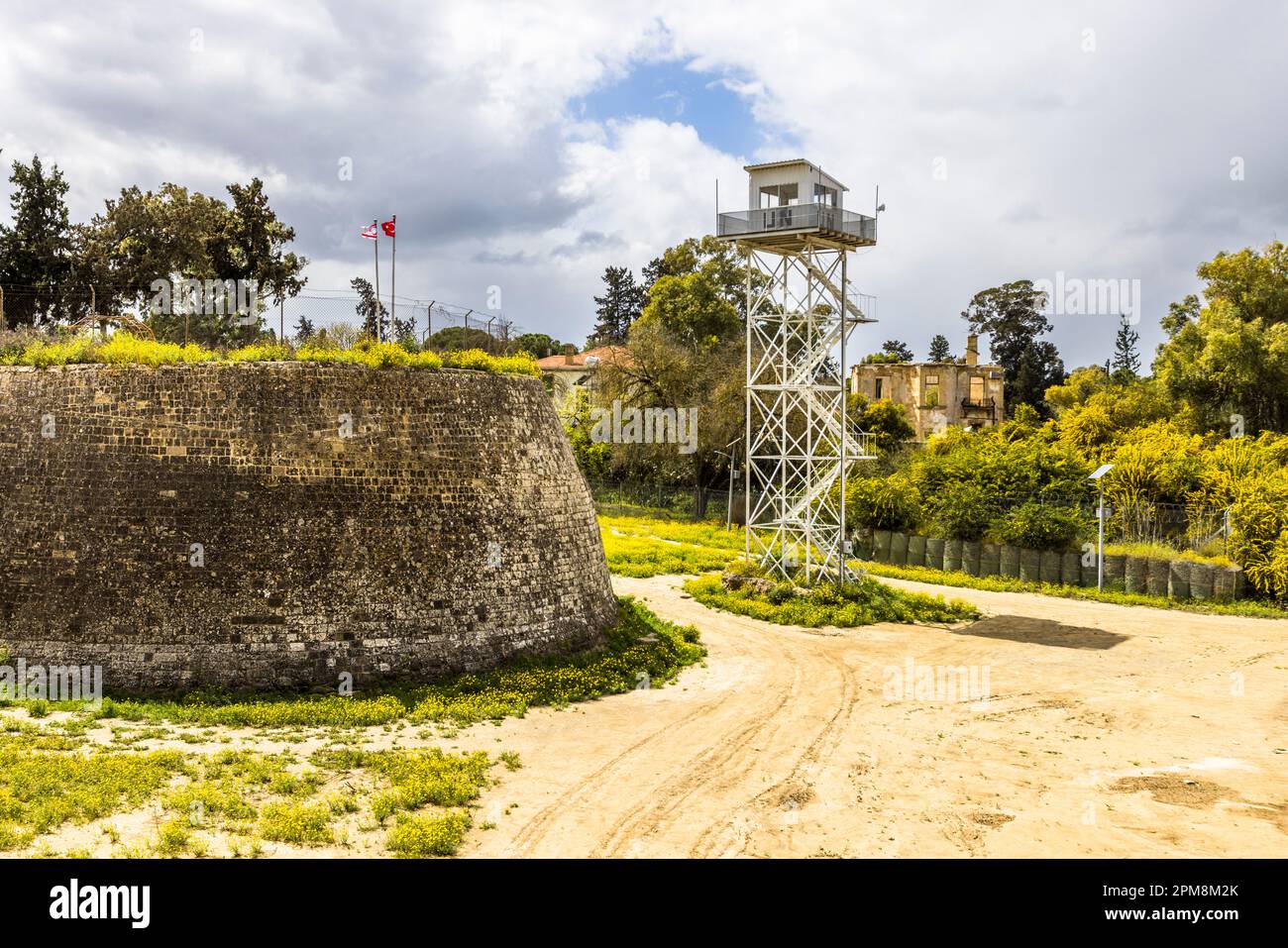 La torre di guardia delle Nazioni Unite nella zona cuscinetto, la cosiddetta linea verde, che attraversa il centro di Nicosia nel 1964 per pacificare le rivolte. Lefkoşa Türk Belediyesi, Cipro. Un Watchtower nella zona cuscinetto con le mura della città veneziana e le bandiere della Repubblica turca di Cipro del Nord e della Turchia Foto Stock