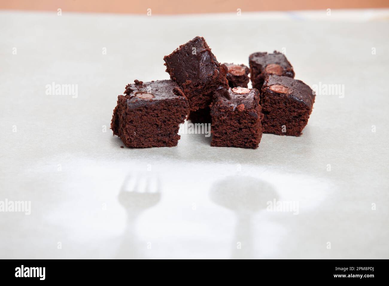 Immagine di quattro pezzi di brownie al cioccolato caldo appena sfornate, servite su un piatto con forchetta Foto Stock