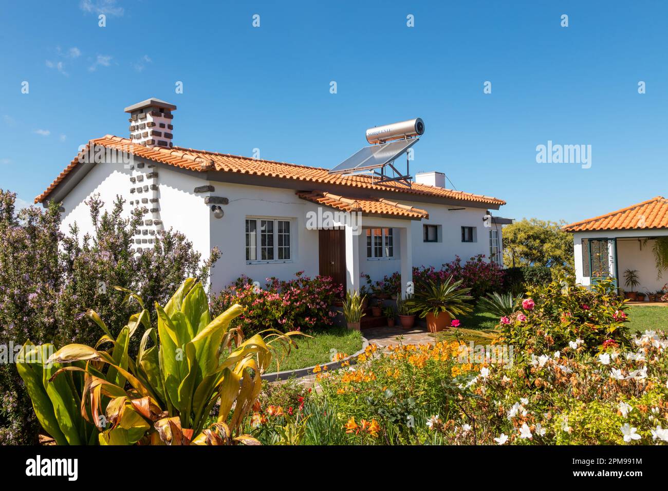 Bungalow casa a Madeira con piccolo pannello solare sul tetto Foto Stock