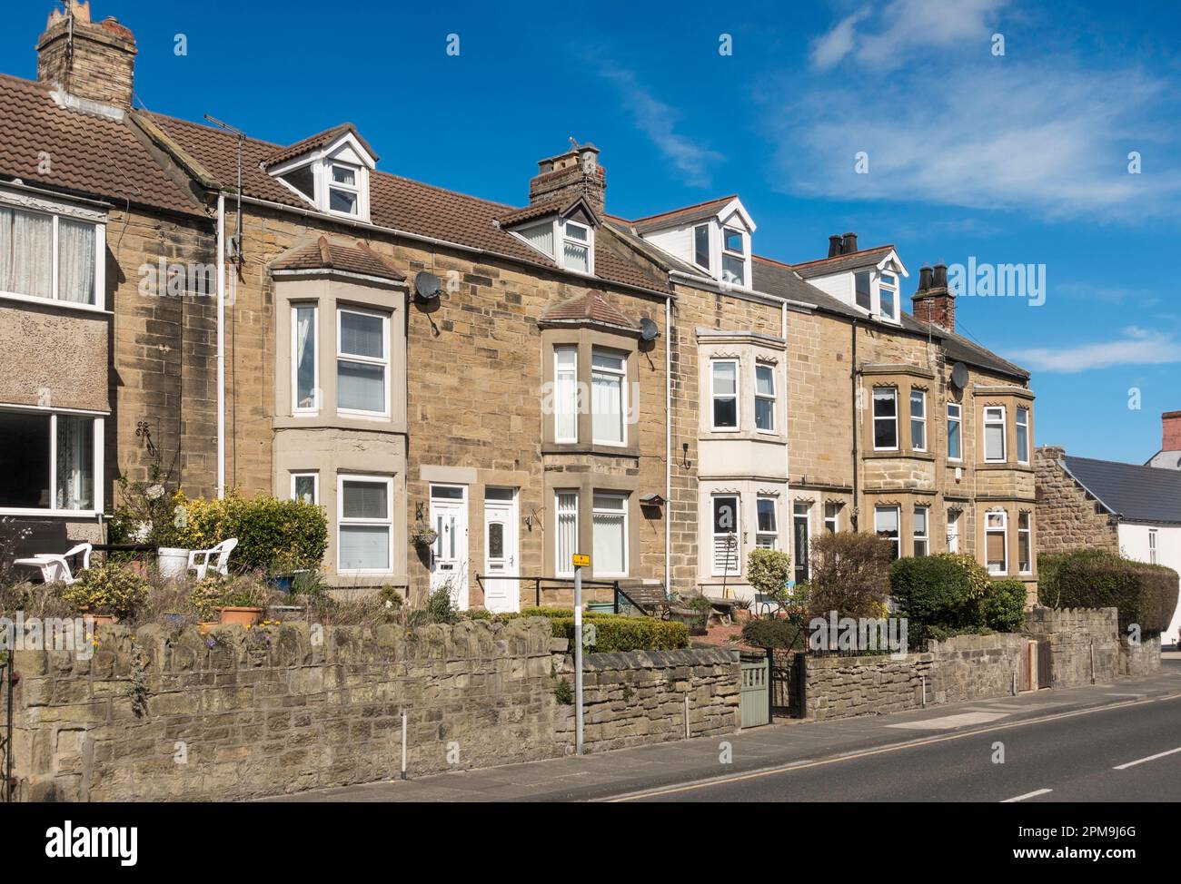 Una fila di case a schiera costruite in pietra a Newbiggin by the Sea, Northumberland, Inghilterra, UK Foto Stock