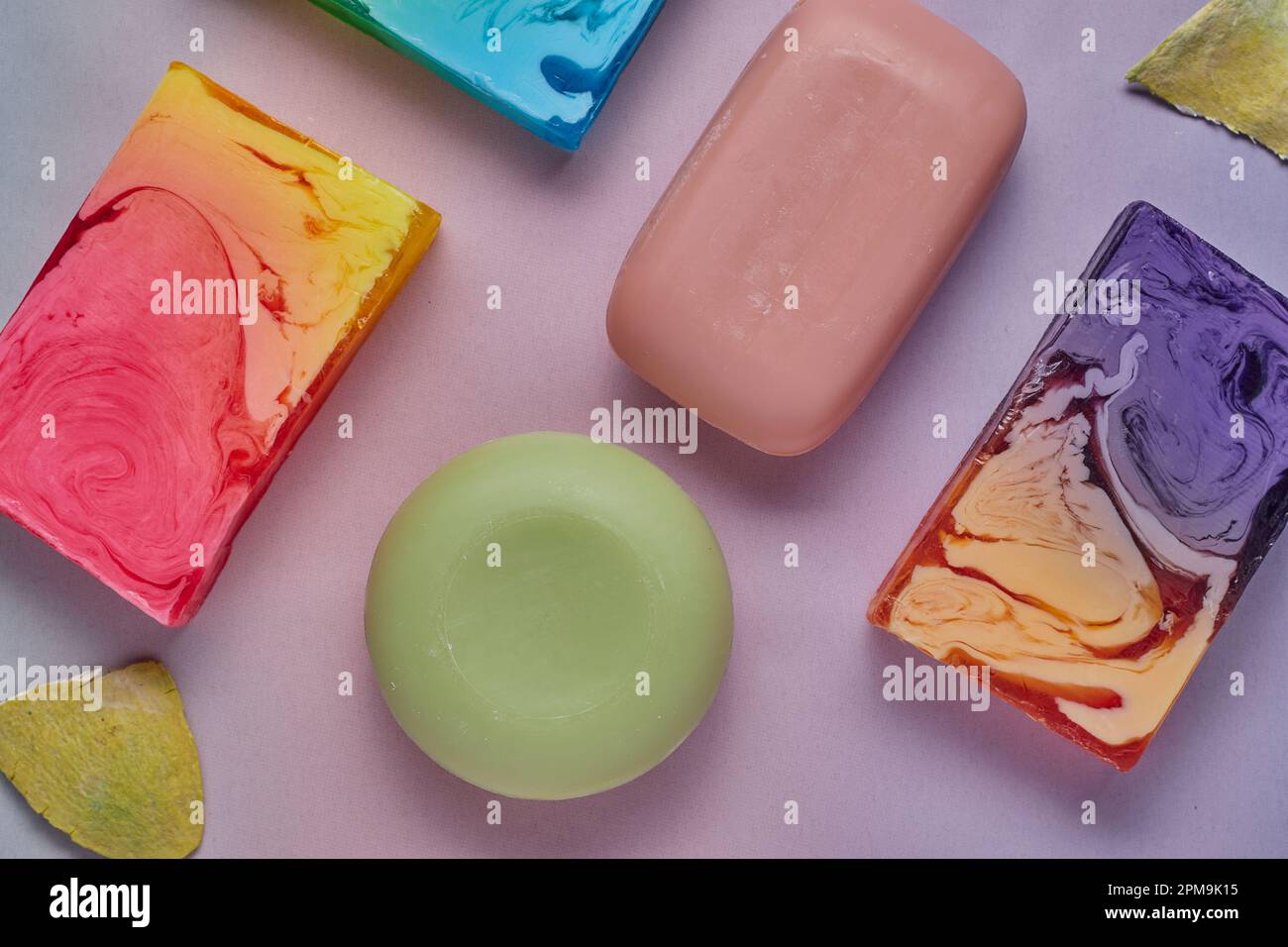 Selezione di saponi colorati su sfondo rosa. Foto Stock