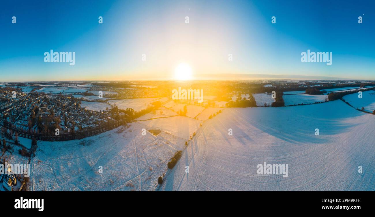 Paesaggio panoramico che guarda verso Cirencester nelle cotswolds all'alba con la neve. Cucito da più fotografie. Foto Stock