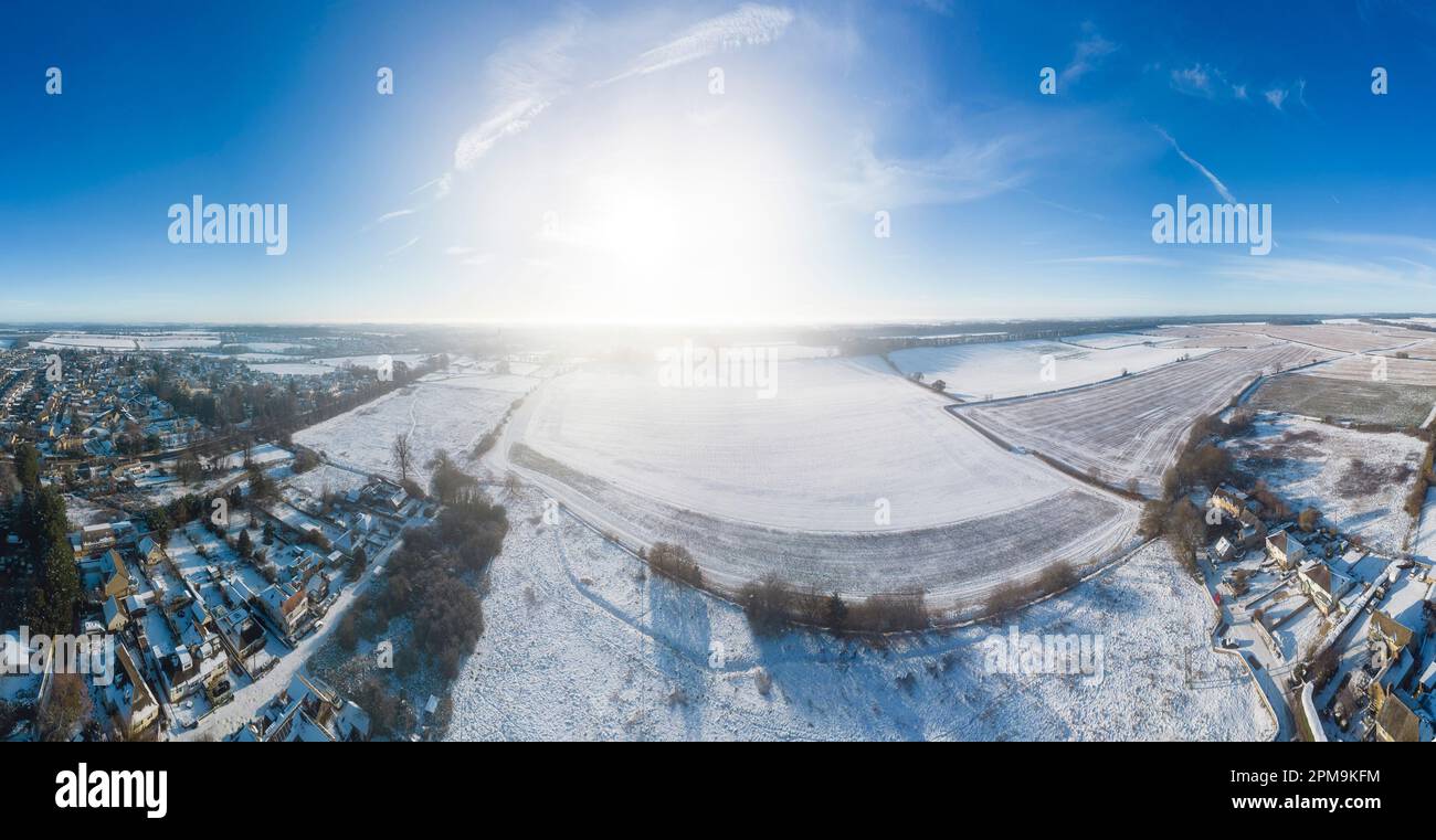 Paesaggio panoramico che guarda verso Cirencester nelle cotswolds all'alba con la neve. Cucito da più fotografie. Foto Stock