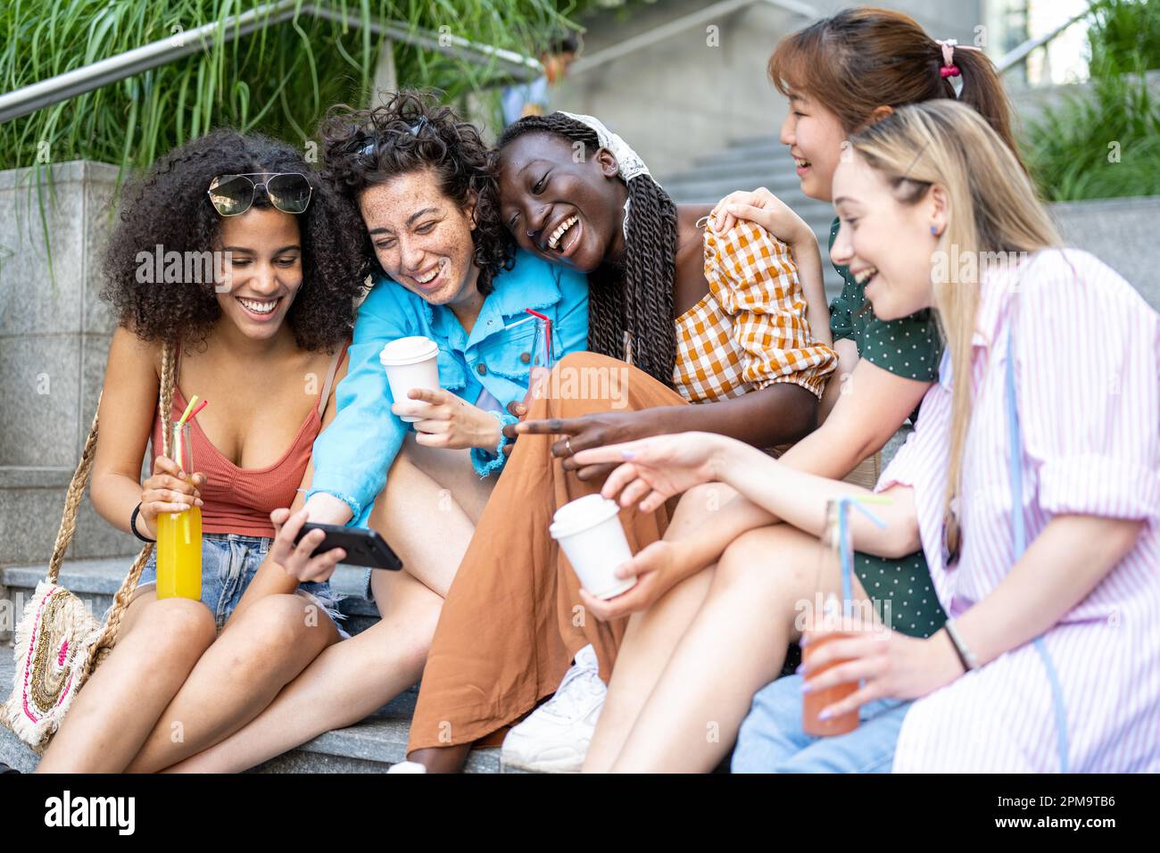 Cinque ragazze multietniche ridendo e prendendo selfie isolato su sfondo bianco Foto Stock