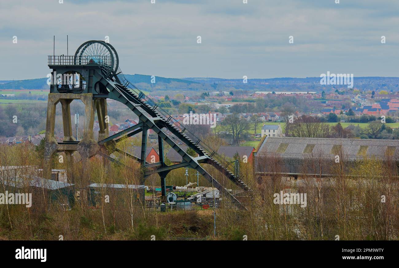 Immagine del paesaggio industriale con una vecchia miniera di carbone e un villaggio sullo sfondo. Foto Stock
