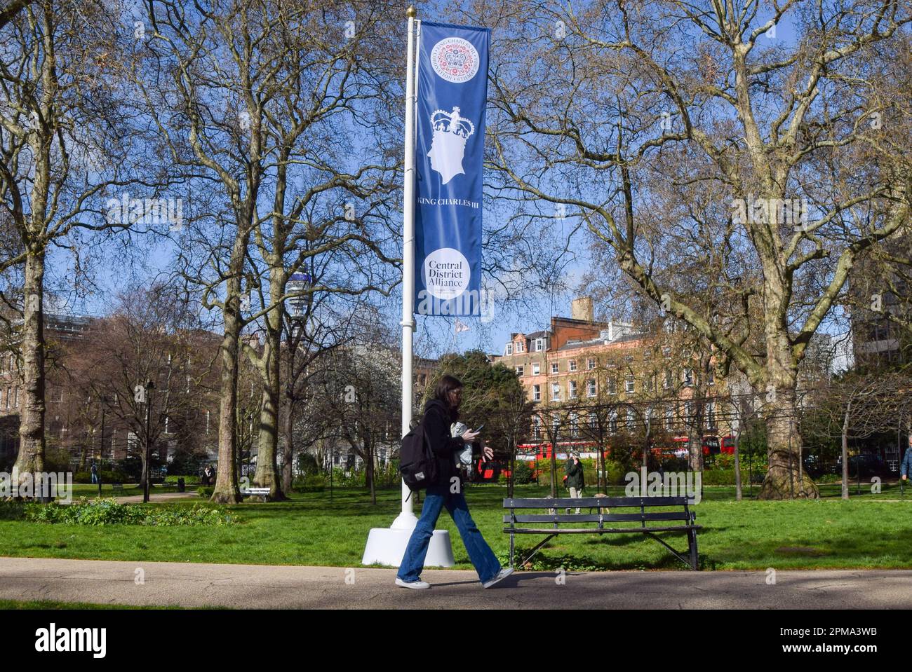 Londra, Regno Unito. 12th aprile 2023. Una donna passa davanti a una bandiera di incoronazione di Re Carlo III in Russell Square, davanti all'incoronazione, che si svolge il 6th maggio. Foto Stock