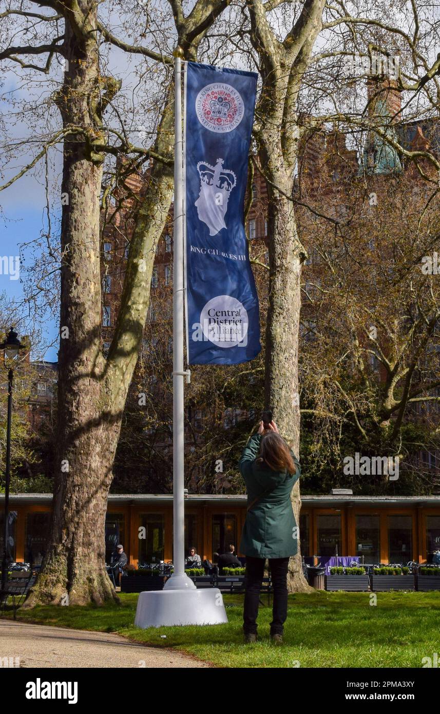 Londra, Regno Unito. 12th aprile 2023. Una donna scatta una foto di un banner di incoronazione di Re Carlo III in Russell Square prima dell'incoronazione, che si svolge il 6th maggio. Foto Stock