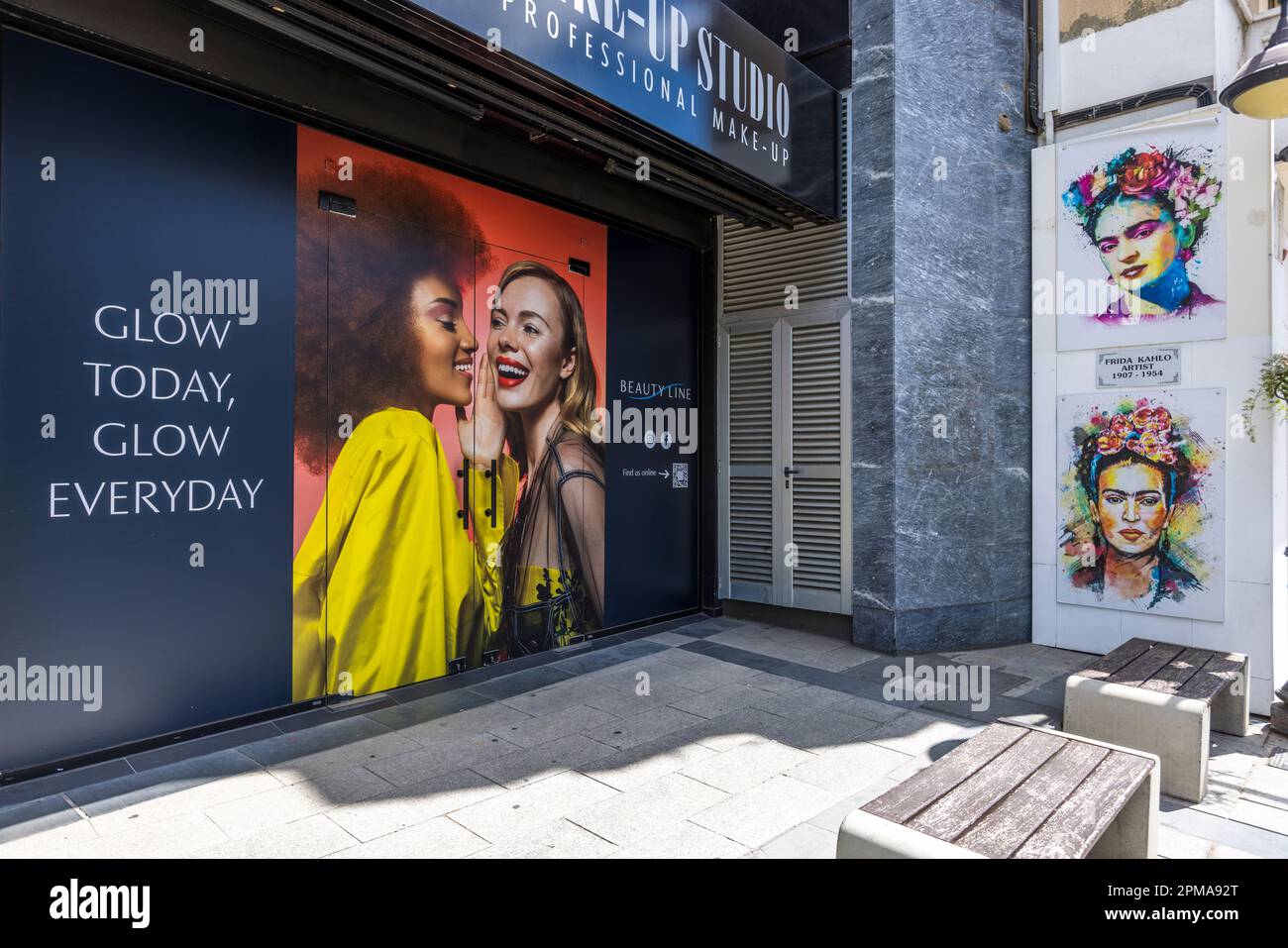 Frida Kahlo memoriale accanto a Makeup studio Beauty Line, che pubblicizza con il seguente slogan: 'Glow Today, Glow Everyday' a Limassol, Cipro Foto Stock