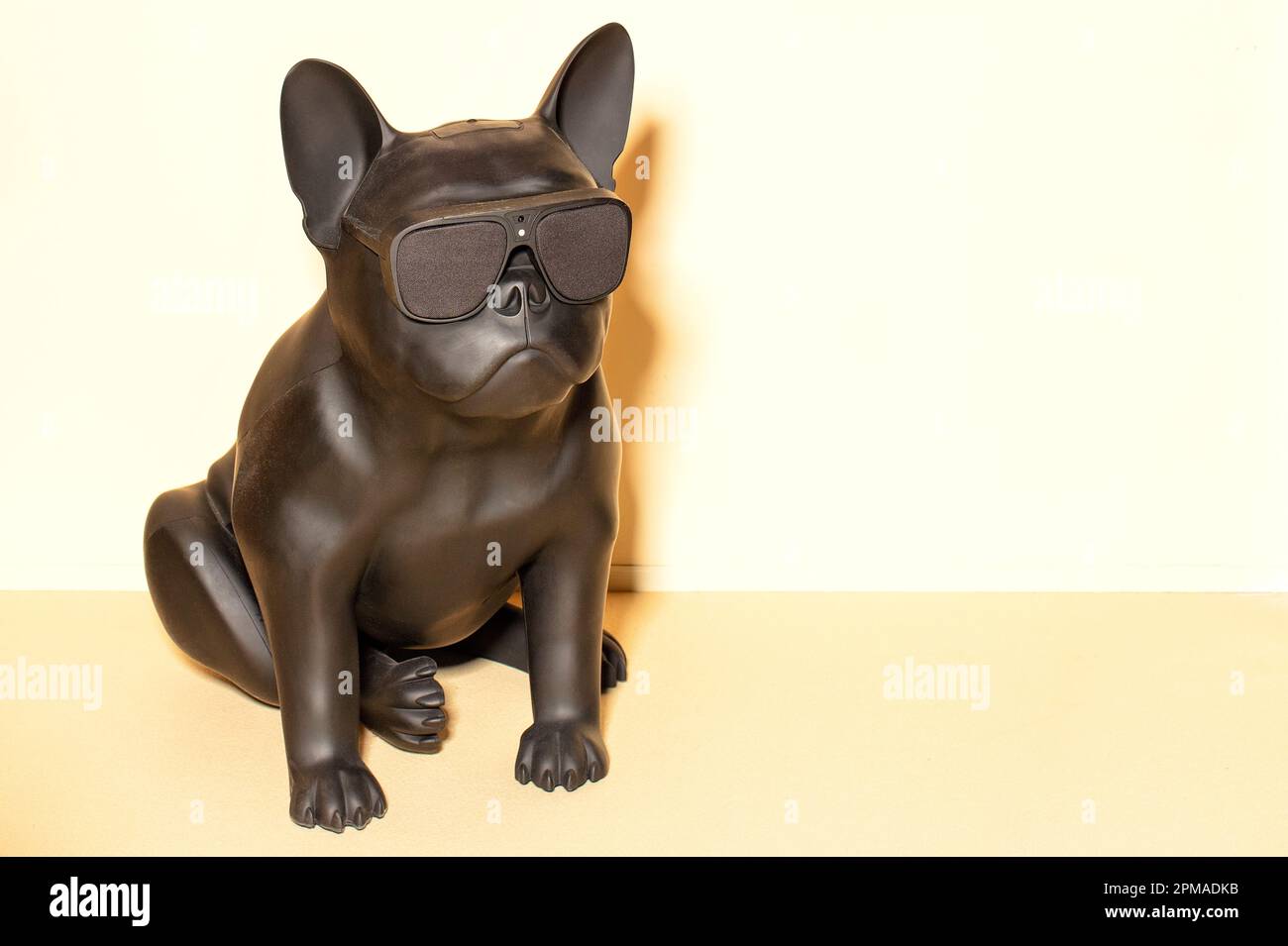 Giocattolo di sicurezza sotto forma di un bulldog francese nero con videosorveglianza e registrazione sonora contro una parete luminosa. Spazio di copia. Foto Stock