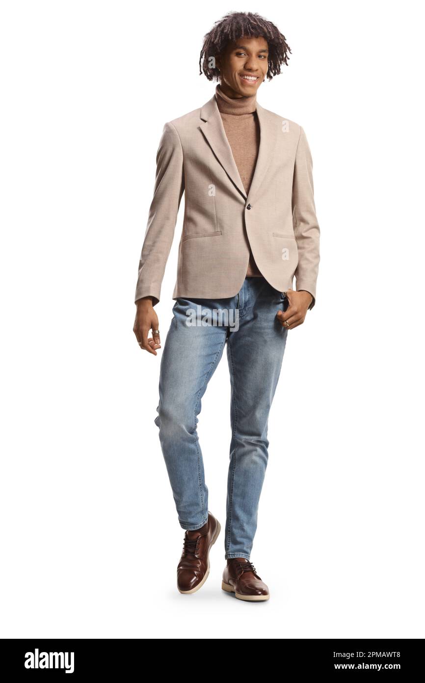 Giovane ed elegante uomo afroamericano in tuta beige e jeans in posa isolata su sfondo bianco Foto Stock