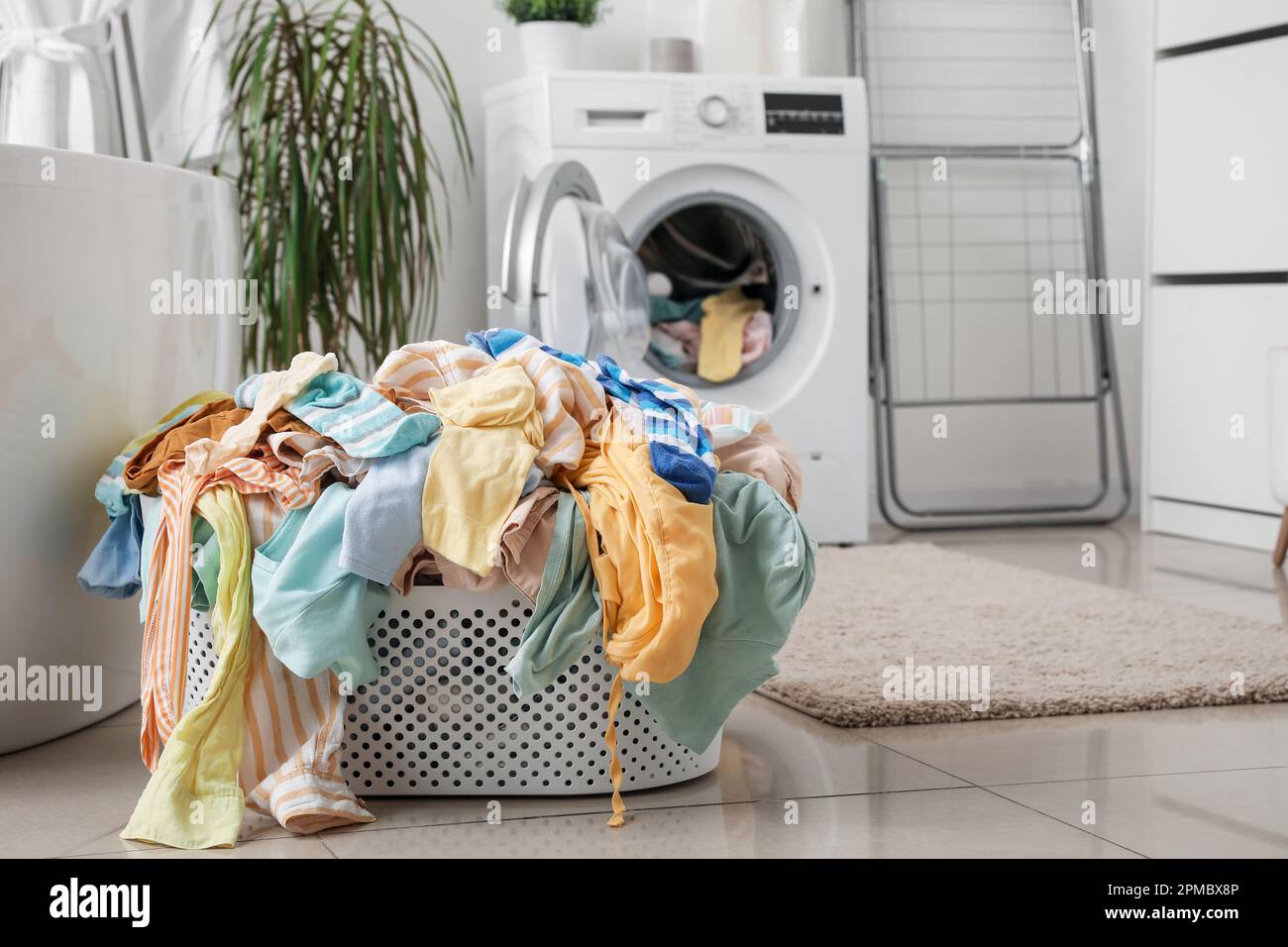 Cestino con vestiti sporchi in bagno Foto stock - Alamy