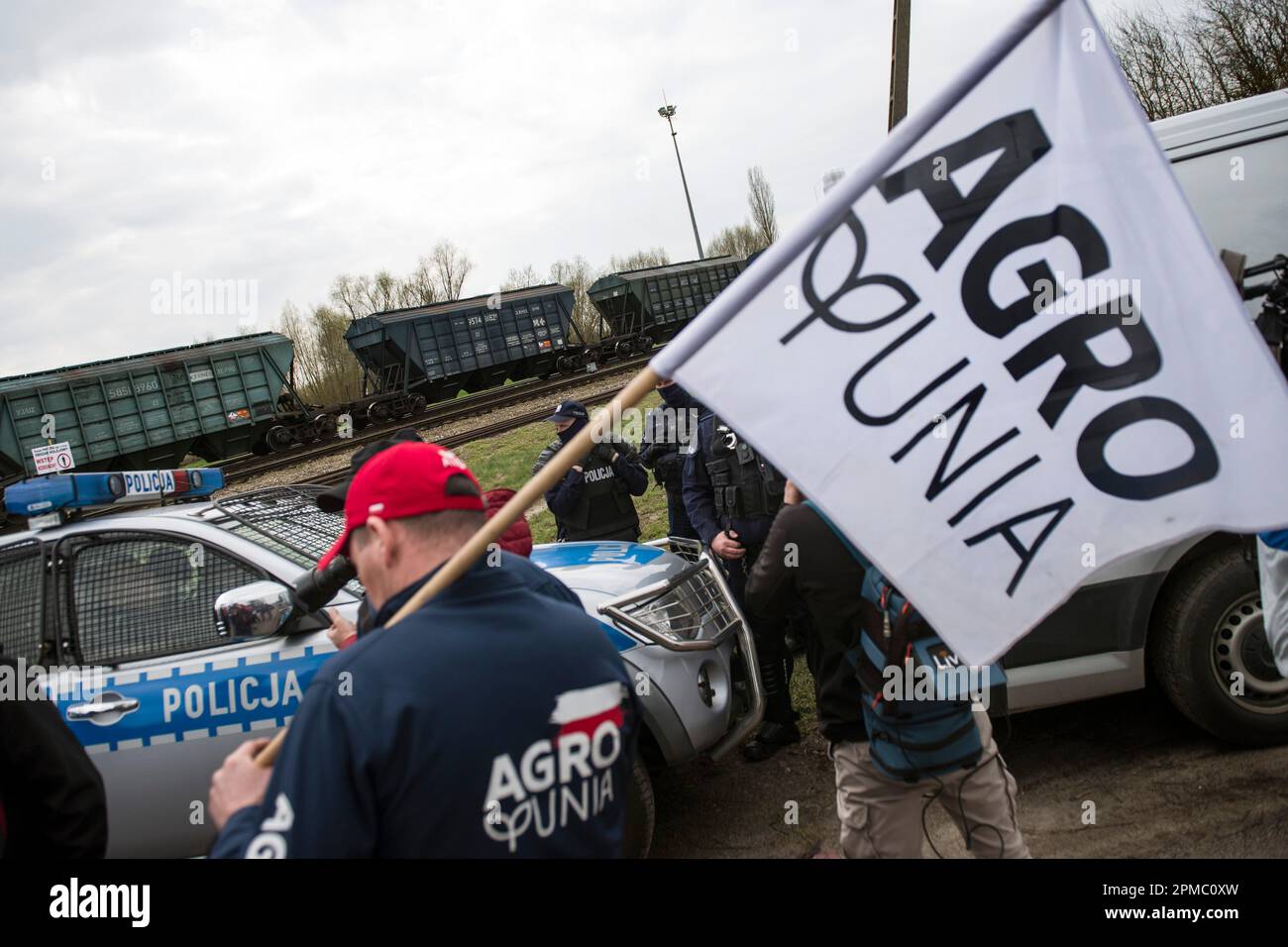 Gli agricoltori che protestano stanno guardando un treno che passa che trasporta grano ucraino alla linea ferroviaria a scartamento largo che attraversa la città di confine di Hrubieszow. La polizia ha impedito l'annunciata protesta di mercoledì mattina degli agricoltori dell'organizzazione AgroUnia (AgroUnion) guidata da Michal Kolodziejczak, che si suppone blocchino la linea ferroviaria a scartamento largo nella città di confine di Hrubieszow, dove il grano proveniente dall'Ucraina entra in Polonia. Come ha detto Michal Kolodziejczak, la protesta è stata denunciata per 7 giorni, ma gli agricoltori sono pronti a prolungarla. (Foto di Attila Husejnow/SOPA Images/Sipa USA) Foto Stock