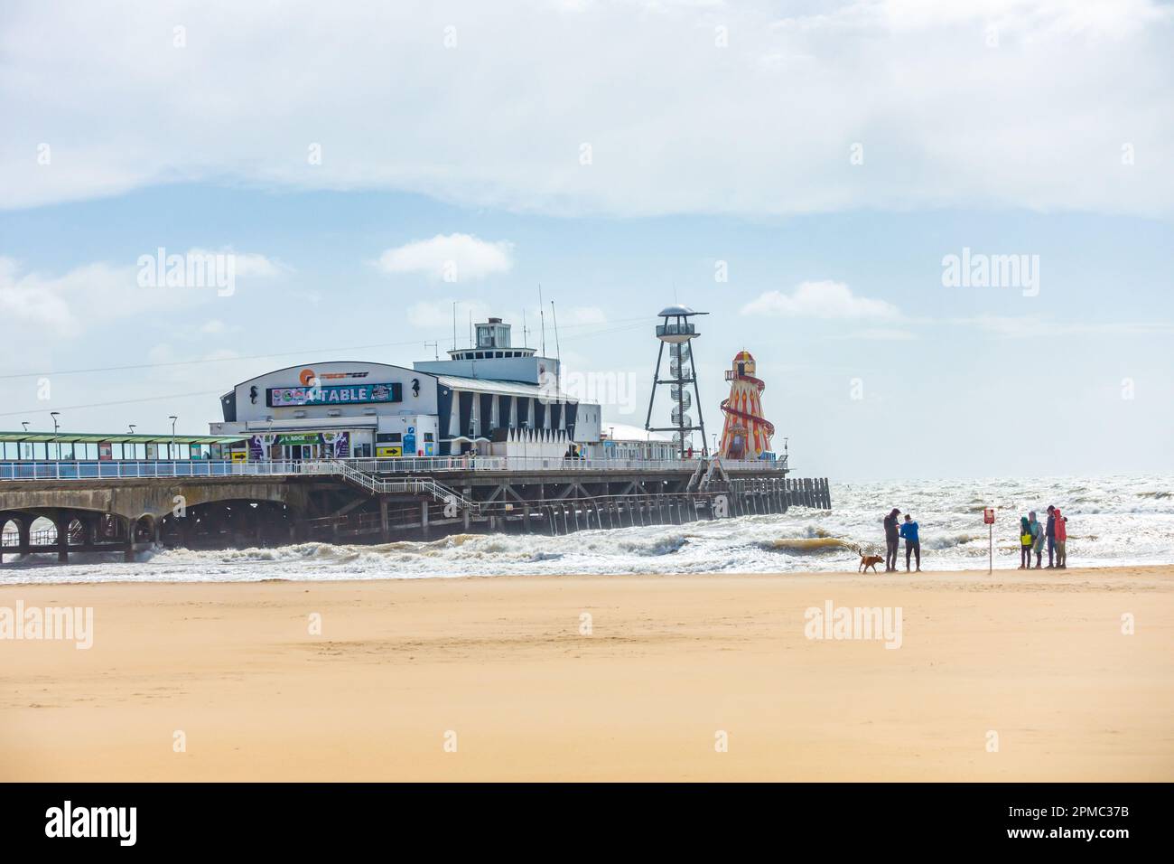 Bournemouth Pier e la spiaggia, una spiaggia di sabbia, tranquilla nel mese di aprile con un cielo tempestoso Foto Stock