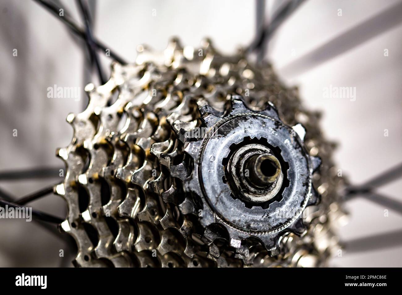 Denti dell'ingranaggio in metallo diversi su una ruota di bicicletta con mozzo posteriore Foto Stock